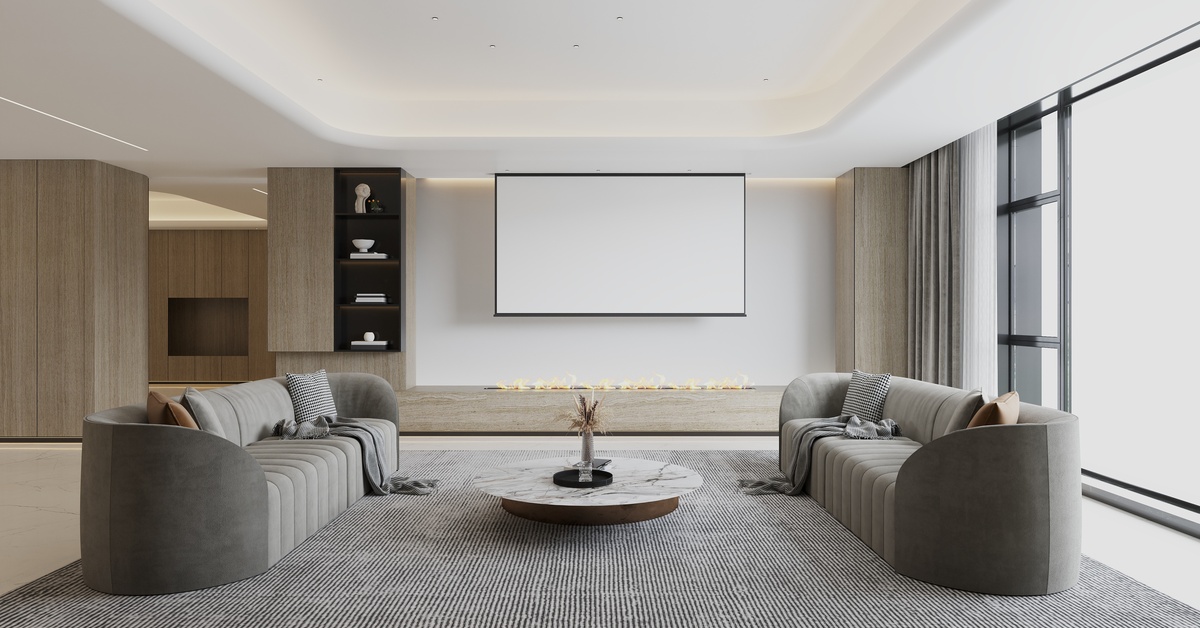 A living room features two gray couches positioned opposite each other, with a television mounted on the wall.